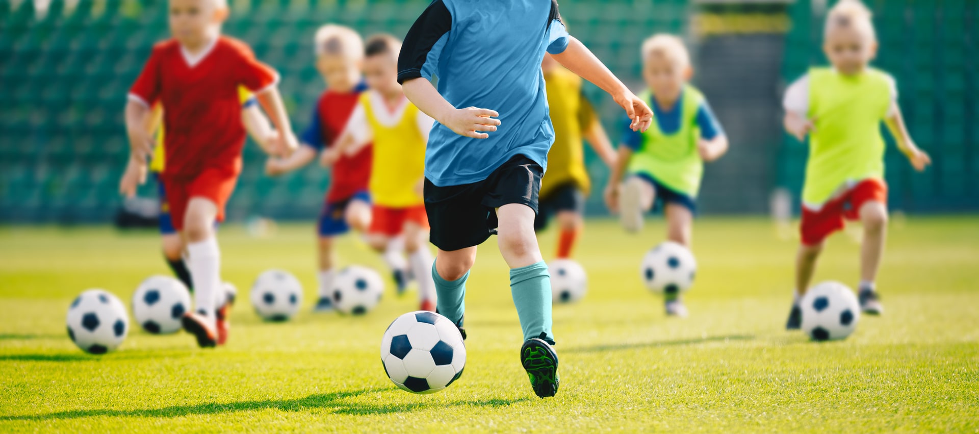 Bilde av små gutter, barn, sparker hver sin fotball, de har på seg vester i ulike farger - Råde IL - Idrettslag