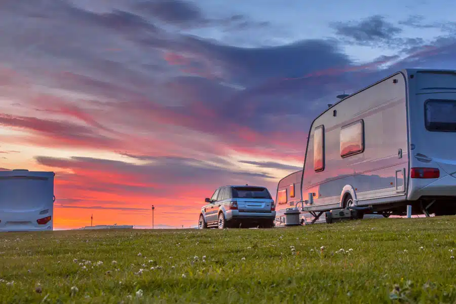 Bilde av en campingplass i solnedgang, campingvogner, campingbiler og biler står stille - Råde IL - Idrettslag