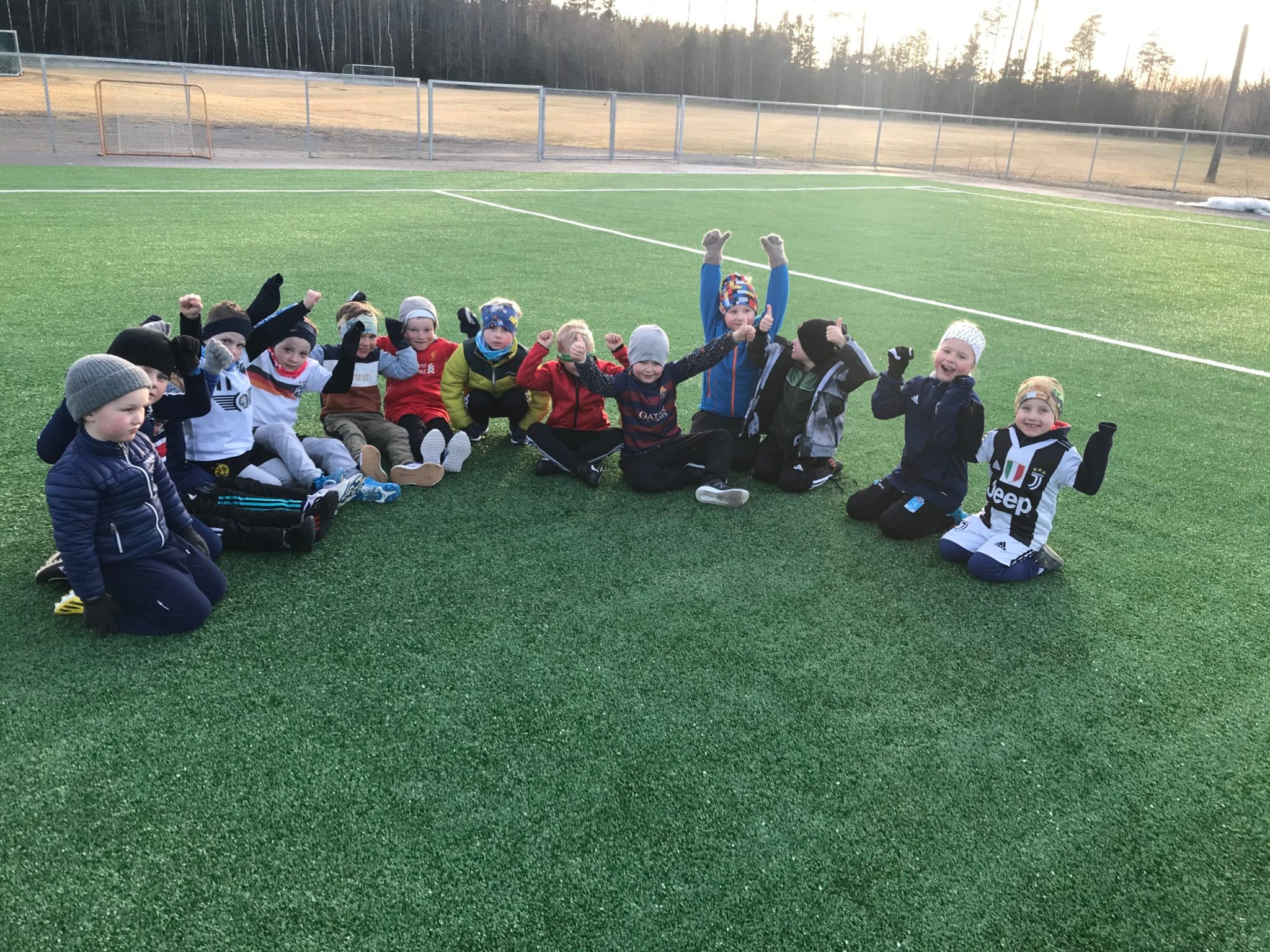 Bilde av barn ute på fotballbanen som har hender i været og jubler - Råde IL - Idrettslag